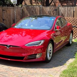 Complimentary EV ChargePoint Charging Station & Rear Parking. Guest utilizing complimentary EV ChargePoint charging station and parking for Tesla Model S.